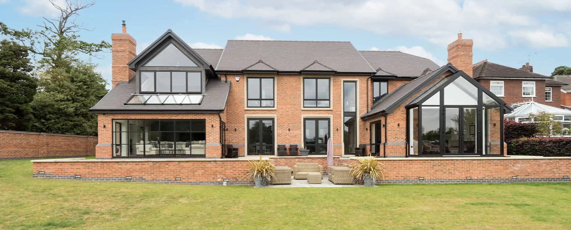 Large house with wrap around lawn and blue sky