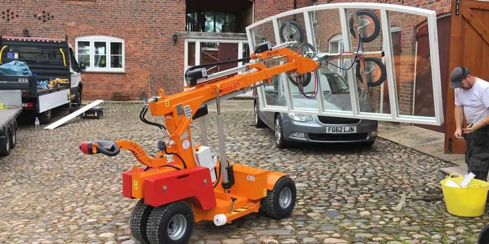 Window fitters using a glazing robot to lift glass