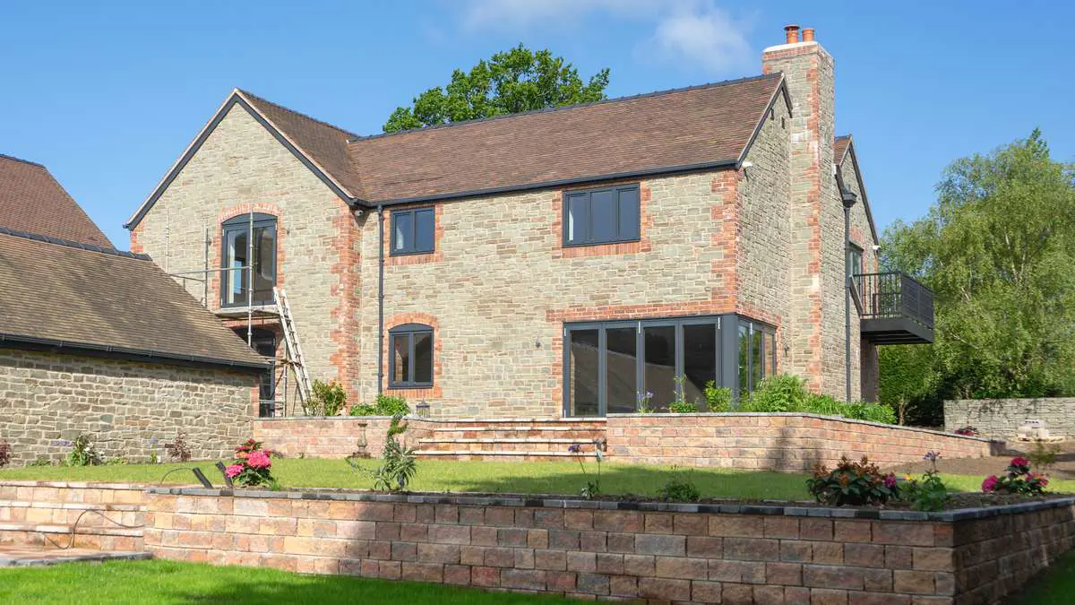 Corner bifold and matching anthracite grey windows from Intenorm installed on this Farmhouse.