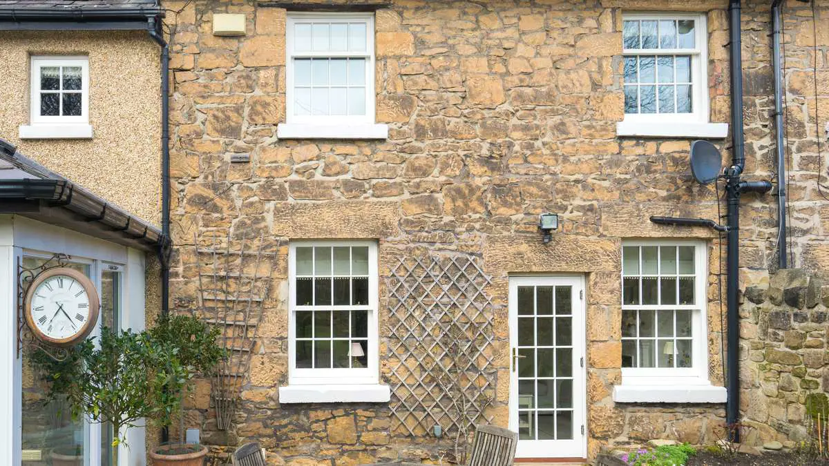 Close up of external view featuring new timber sash windows and single glazed door.