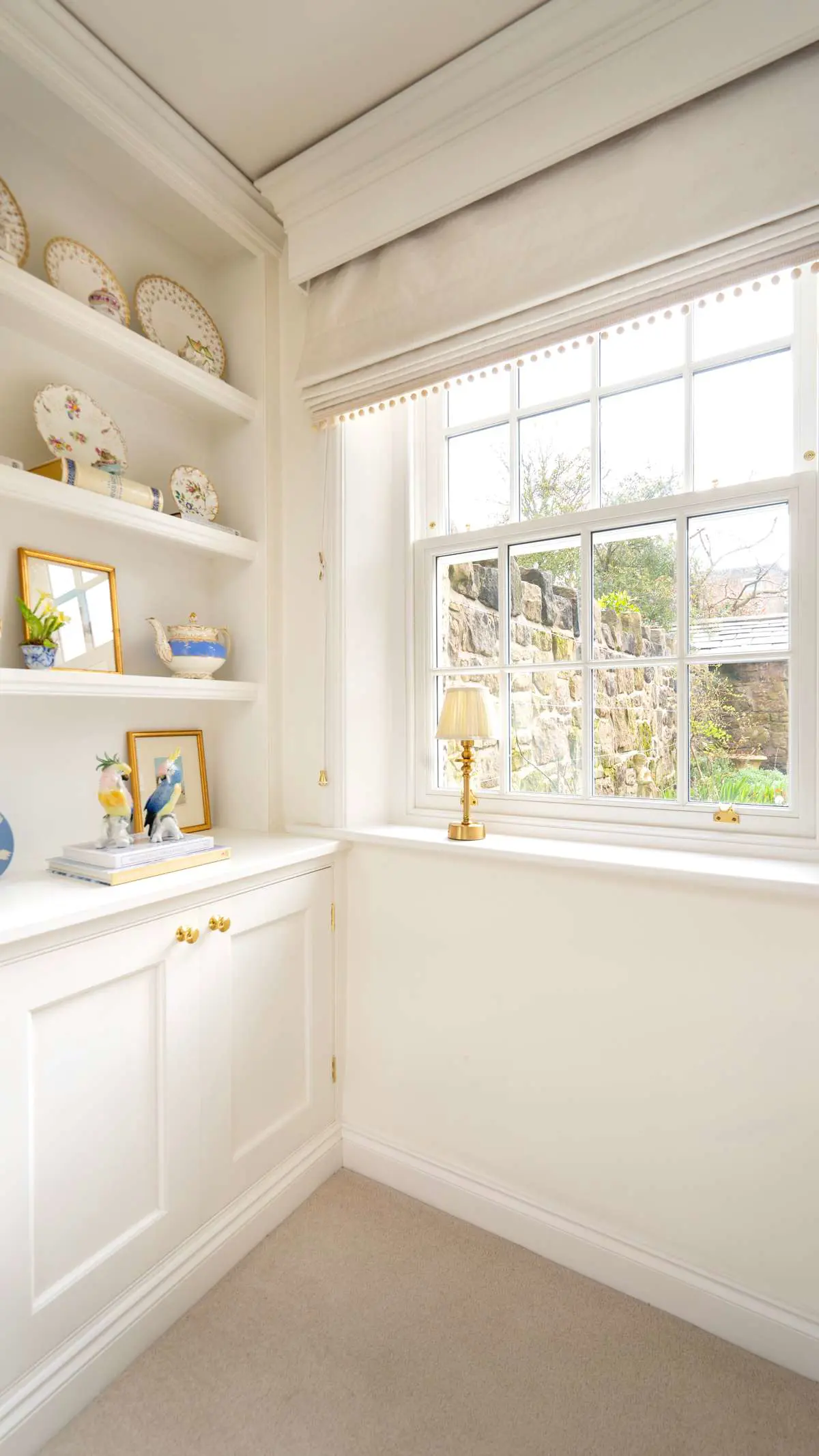 Close up of timber sash window installation with timber alcove cupboard with brass hardware throughout.