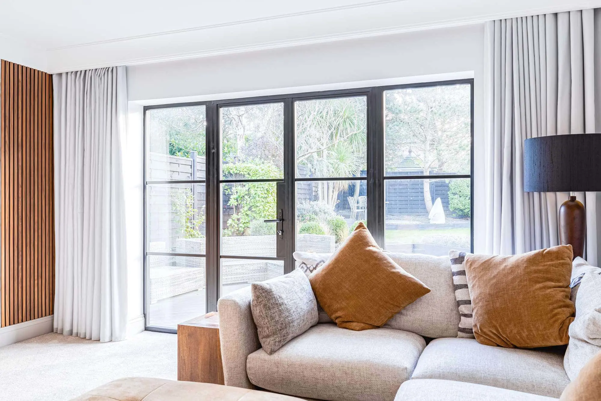 Internal view of black aluminium French doors with horizontal glazing bars and large sidelights.