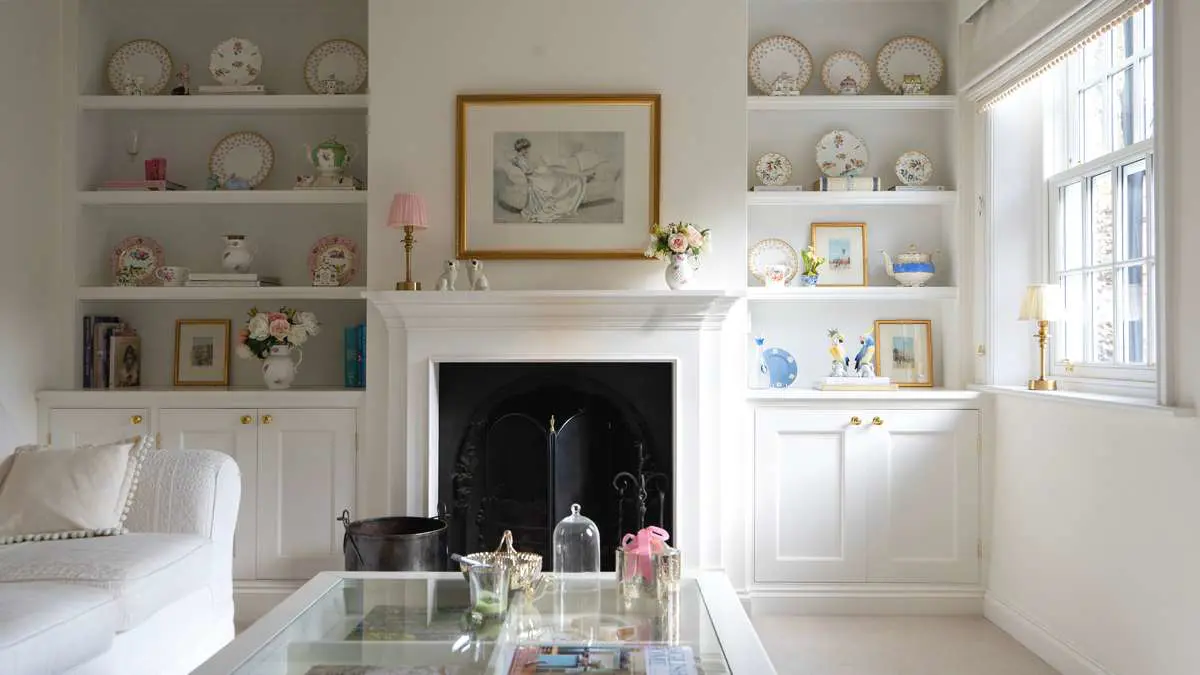 Period home living room with fireplace and alcove cabinets, featuring the installation of a timber sliding sash window.