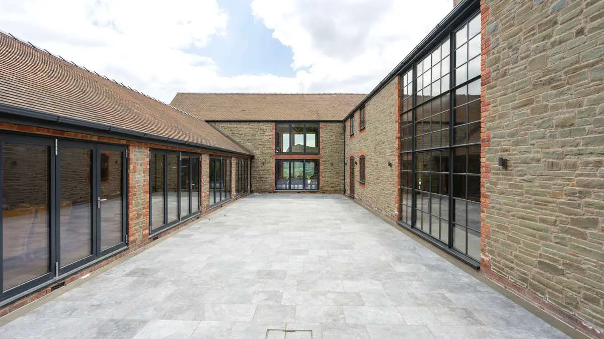 Straight on view of the large courtyard space featuring a range of different products including both steel and aluminium windows and doors.