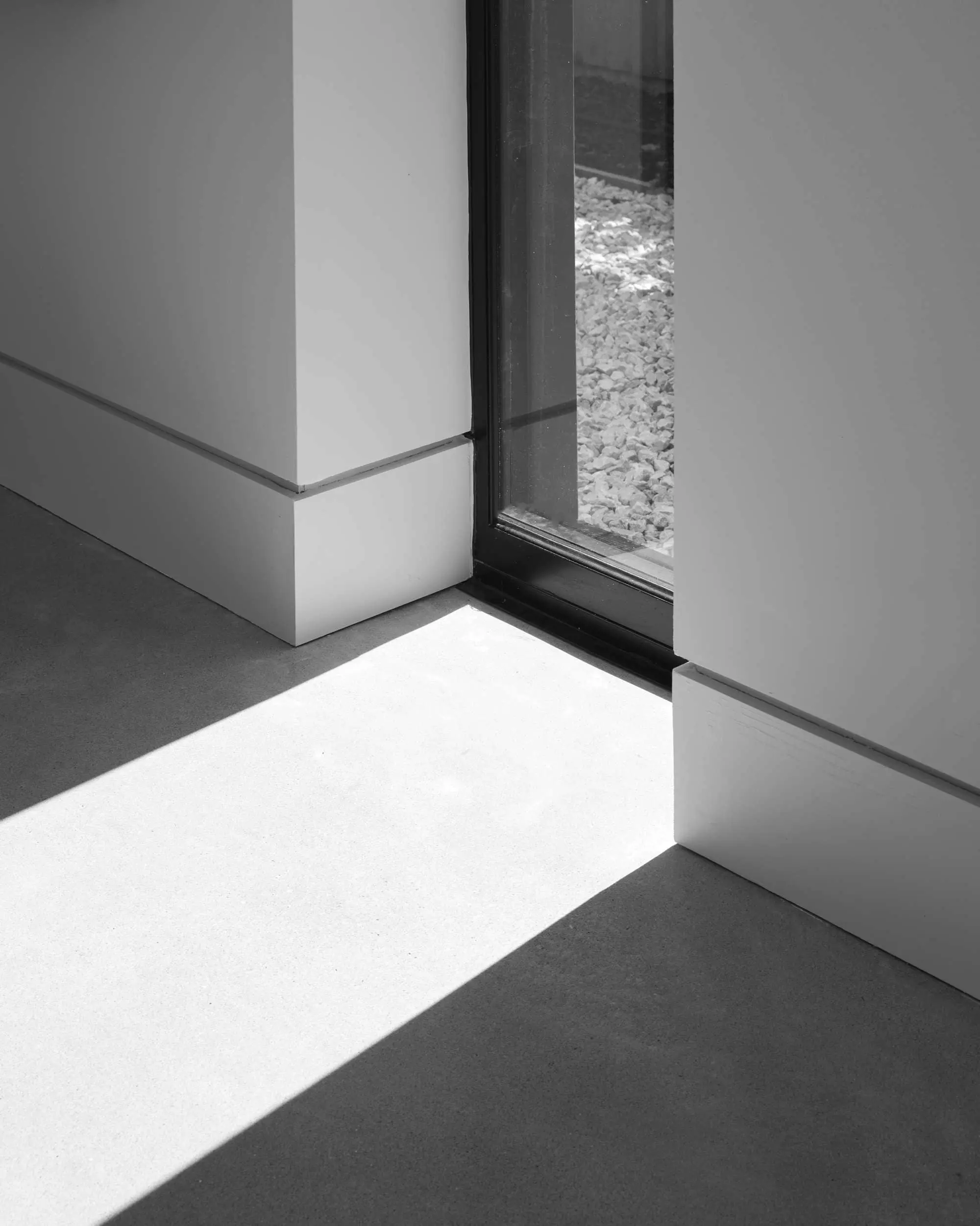 Black & white image of light casting on aluminium window.