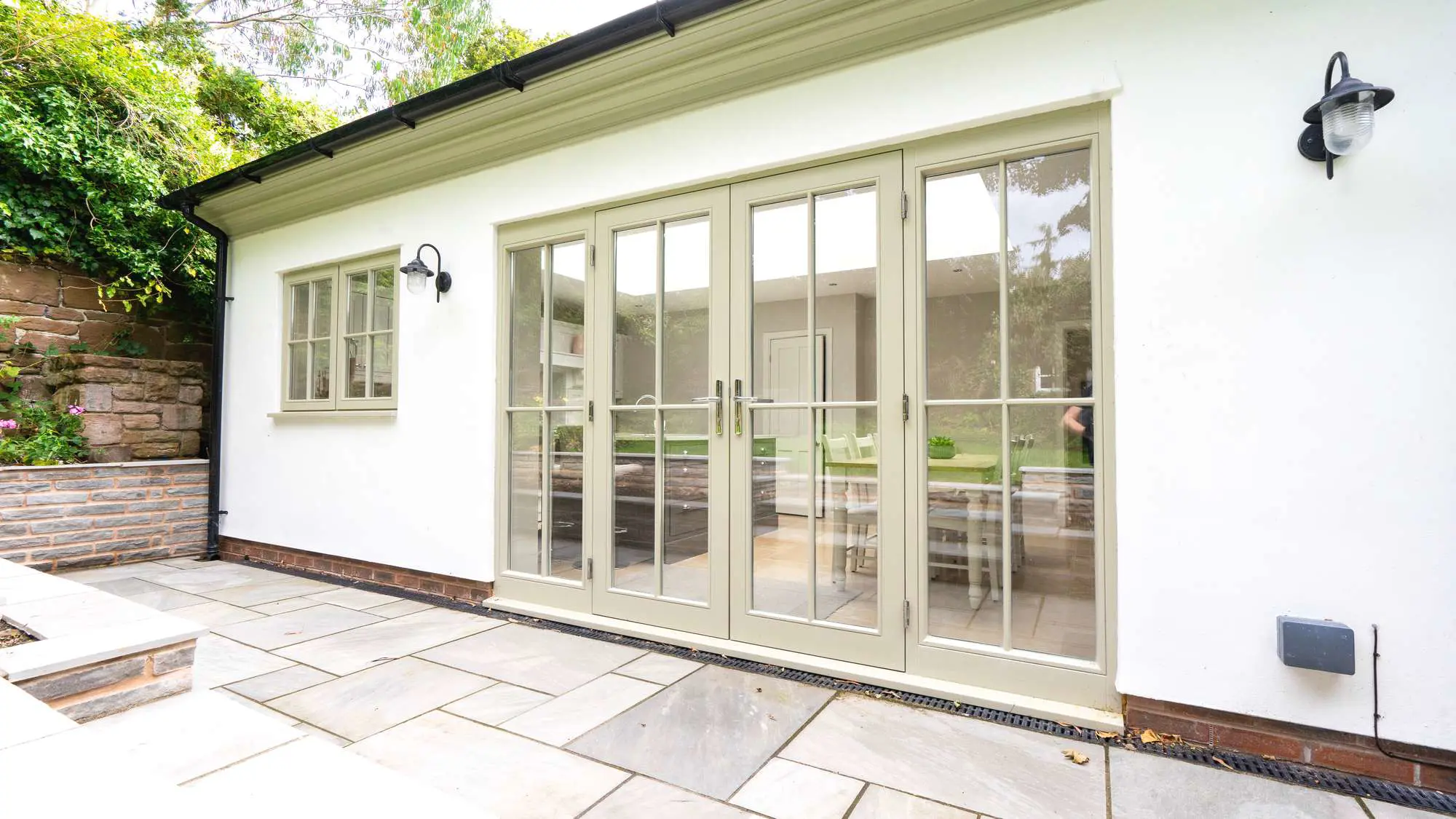 Close up of timber doors on a flat roof orangery extension, rendered in white.