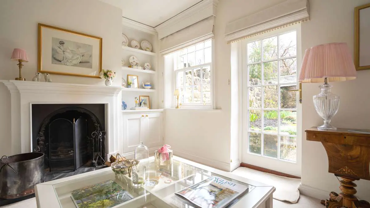 Timber window and door installation in white with astragal bars and traditional hardware.