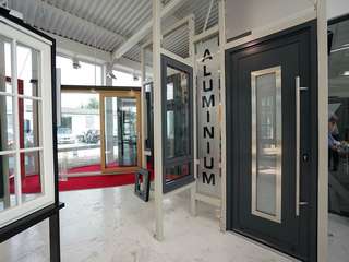 Aluminium entrance door in RAL 7016 with centre glass panel and oversized stainless steel handle.